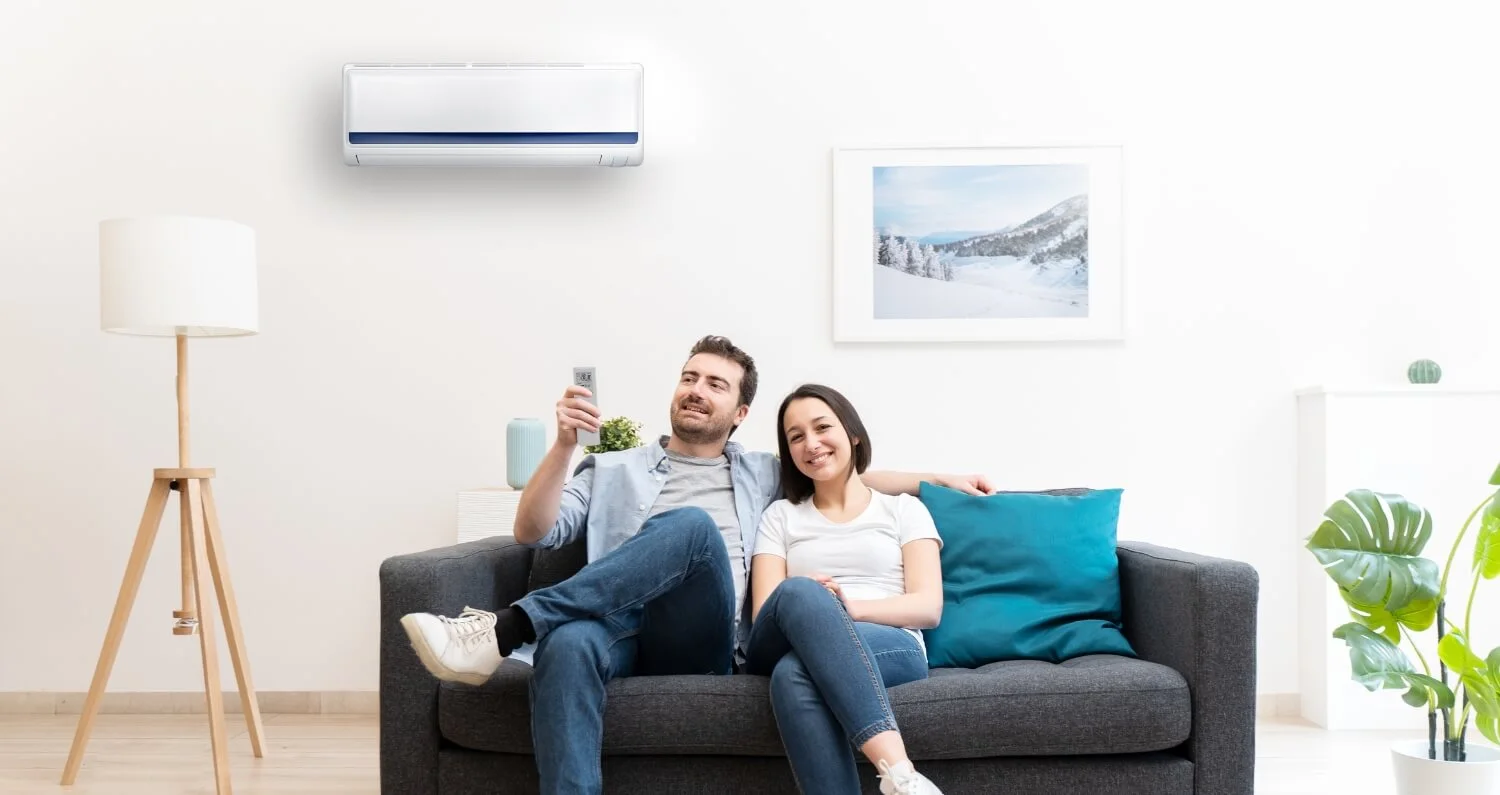 Couple sitting on couch turning on AC equipment